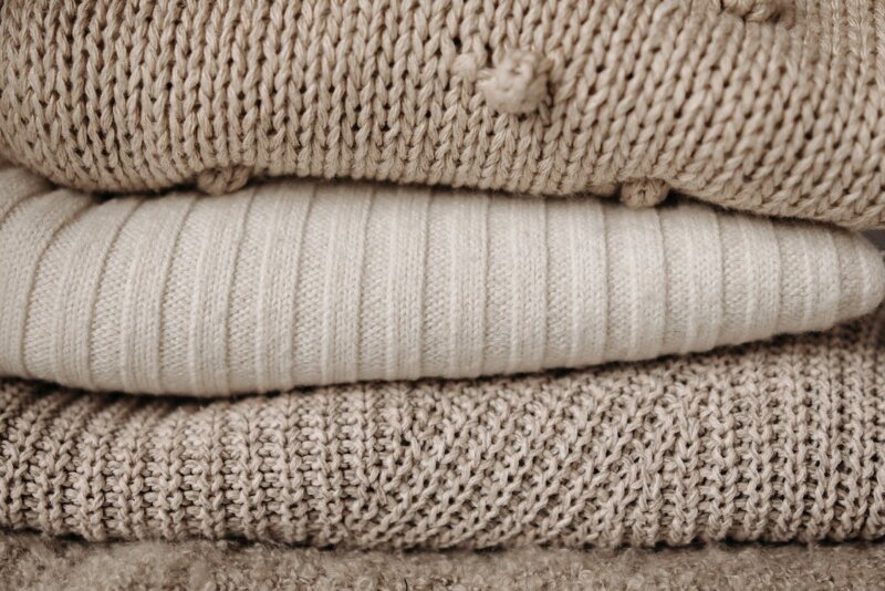 Tips från Grumme för att tvätta ull. En hög med tröjor i ull i beige färg. 