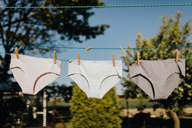 Tvätta underkläder med Grumme. 3 par trosor som hänger på en tvättlina. 